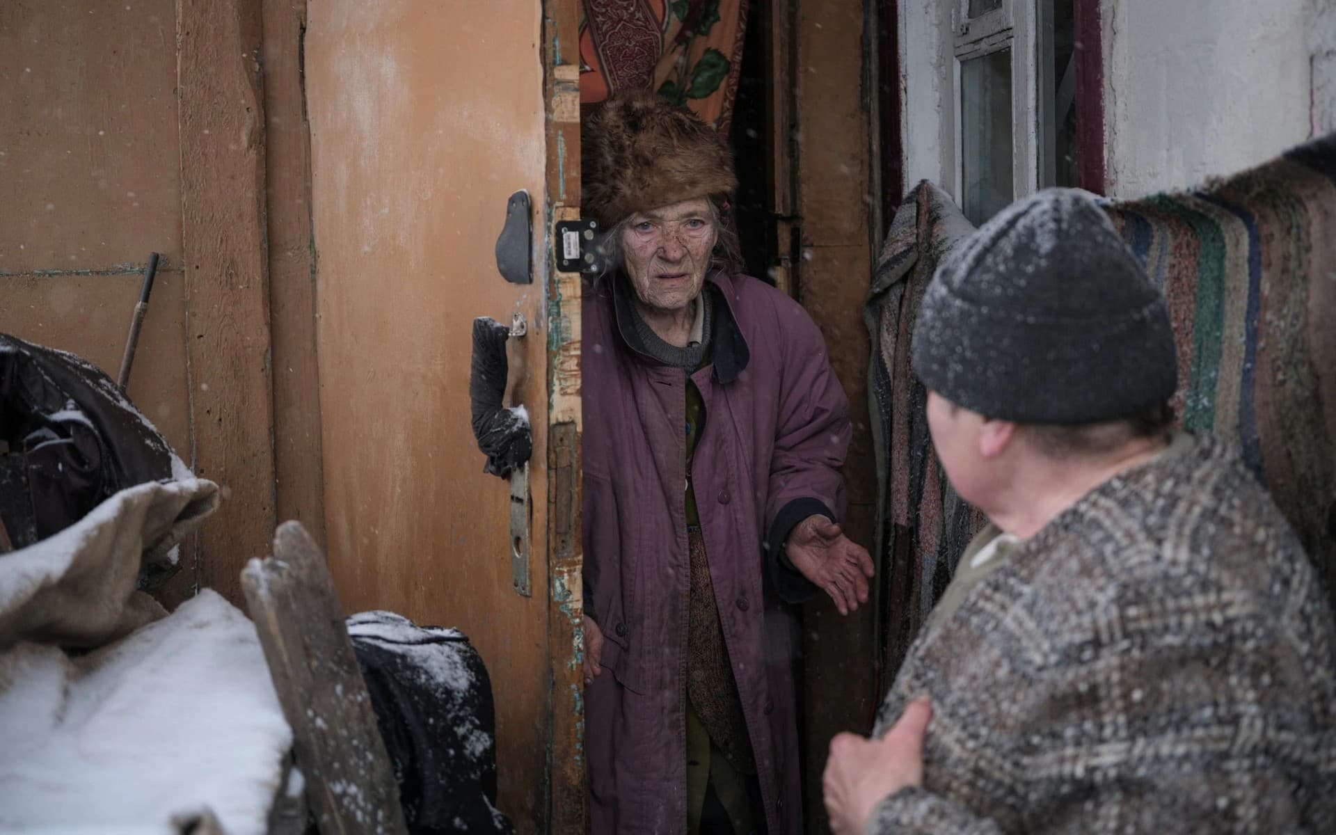 Local resident Olha, helps her neighbour Lidiia Chynyakova, 89, evacuate from her home in Bakhmut