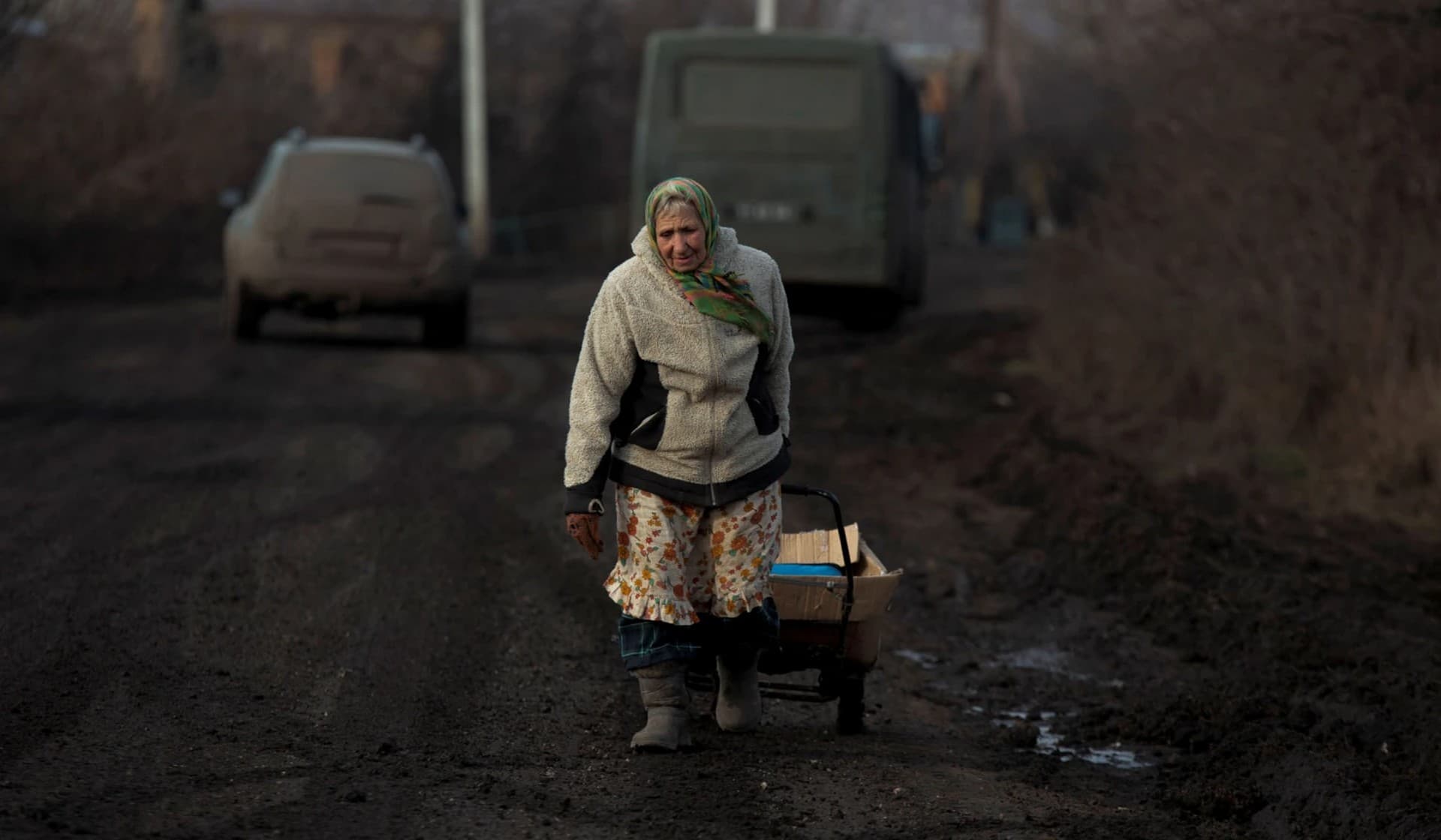 Local resident carries a cart with humanitarian aid in the village of Nykyforivka