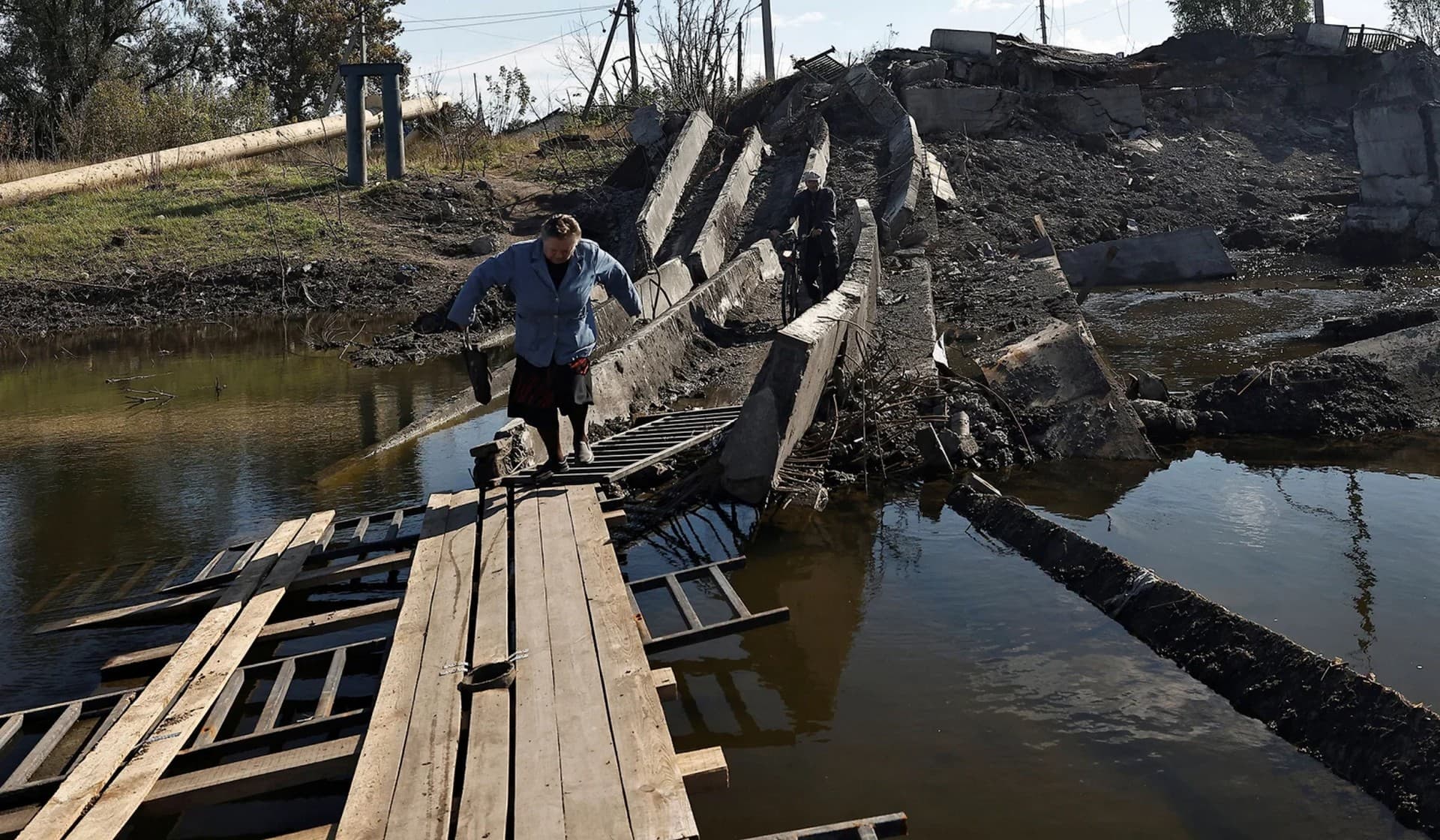 A local resident walks through the ruins of the bridge in Bakhmut