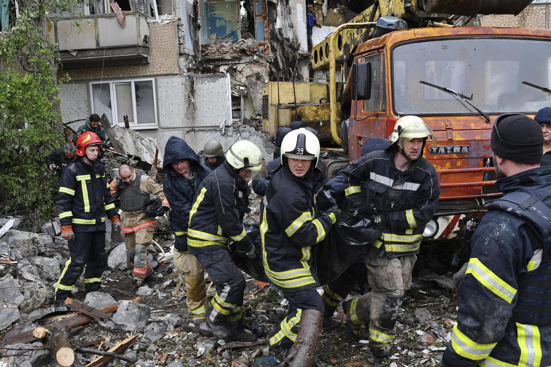 Rescuers carry the body of a civilian at a site of an apartment building destroyed by Russian shelling in Bakhmut