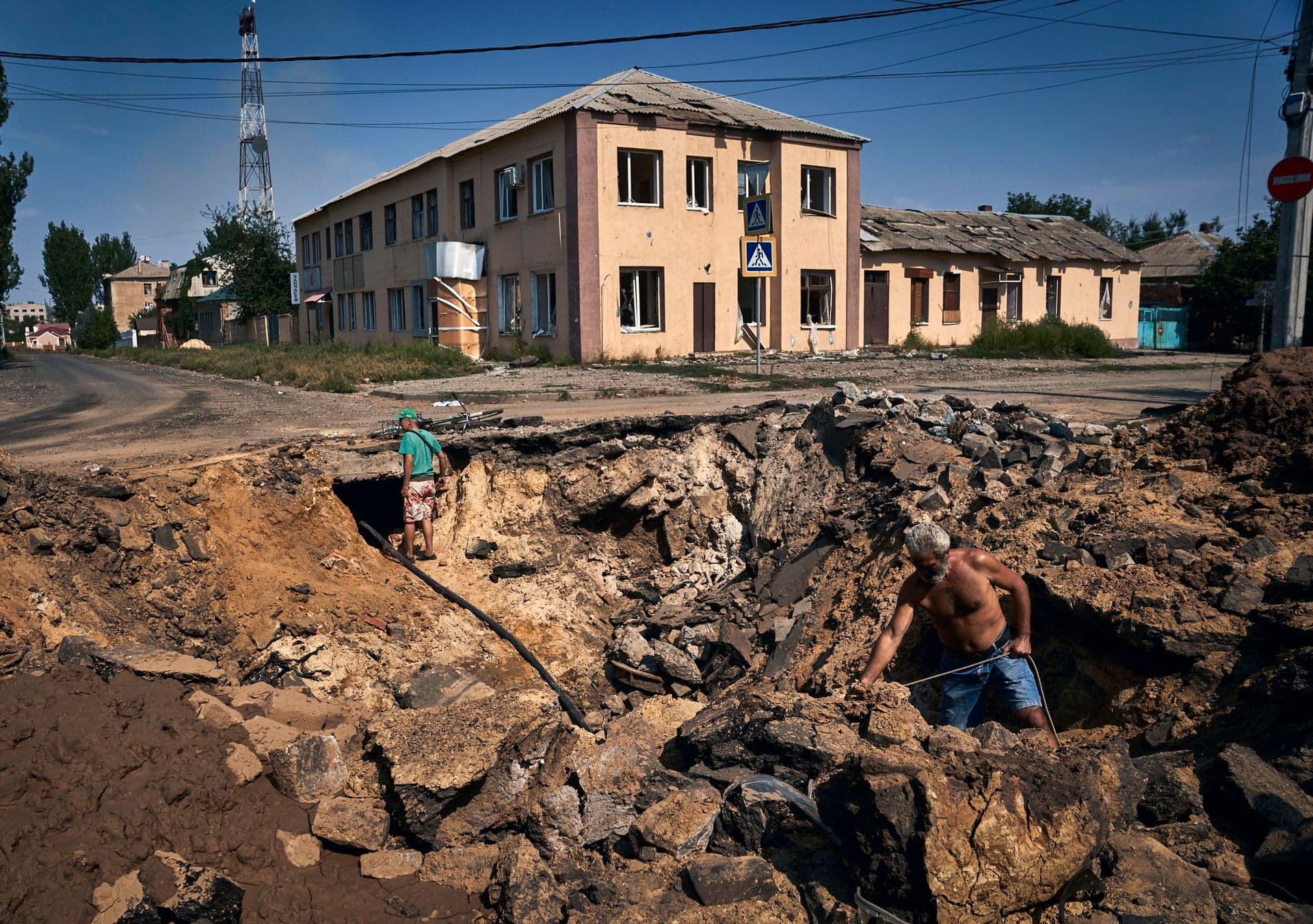 Local residents take water with an air bomb from a partially restored water supply in Bakhmut