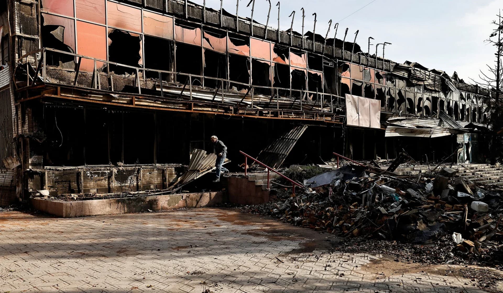 A local resident walks past a destroyed building in Bakhmut