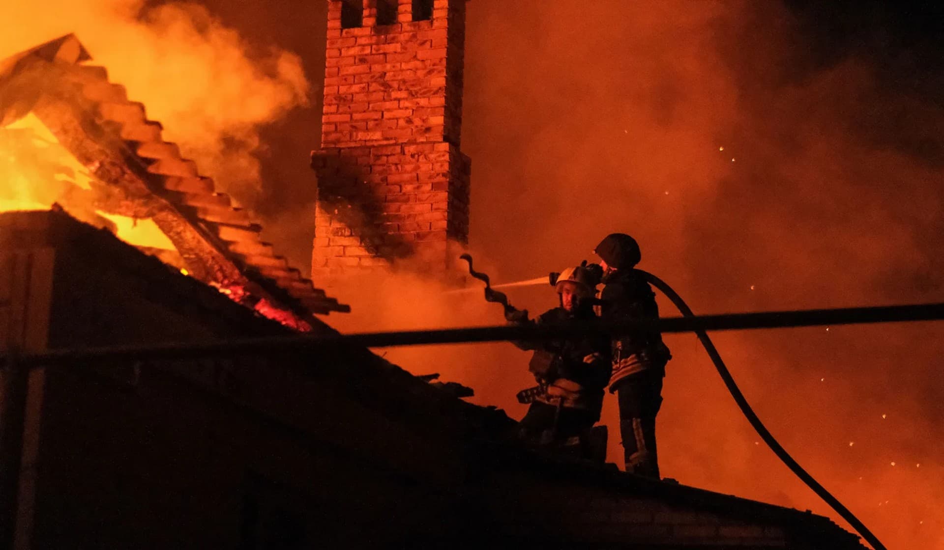 A Ukrainian firefighter puts out fire in a residential house after a Russian military strike in Bakhmut
