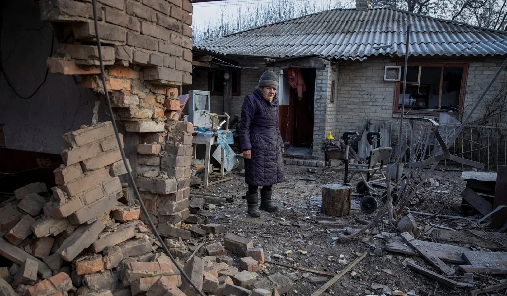 Local resident Yevheniia Yepifanova, 83, stands next to her house damaged by a Russian military strike in Chasiv Yar