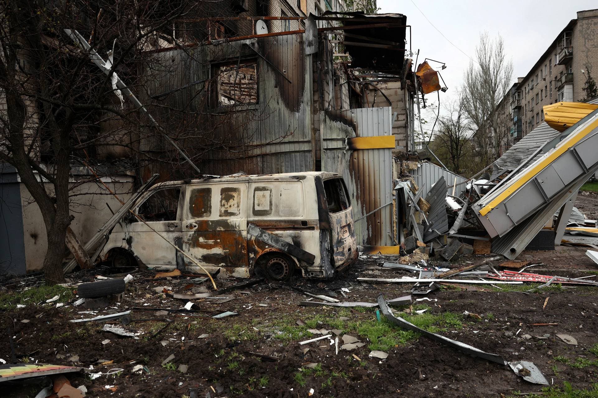A destroyed vehicle near a residential building damaged by shelling in the devastated frontline city of Bakhmut