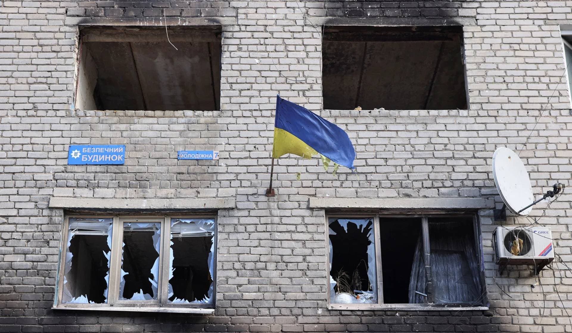 A ragged Ukrainian national flag on a damaged building in Siversk
