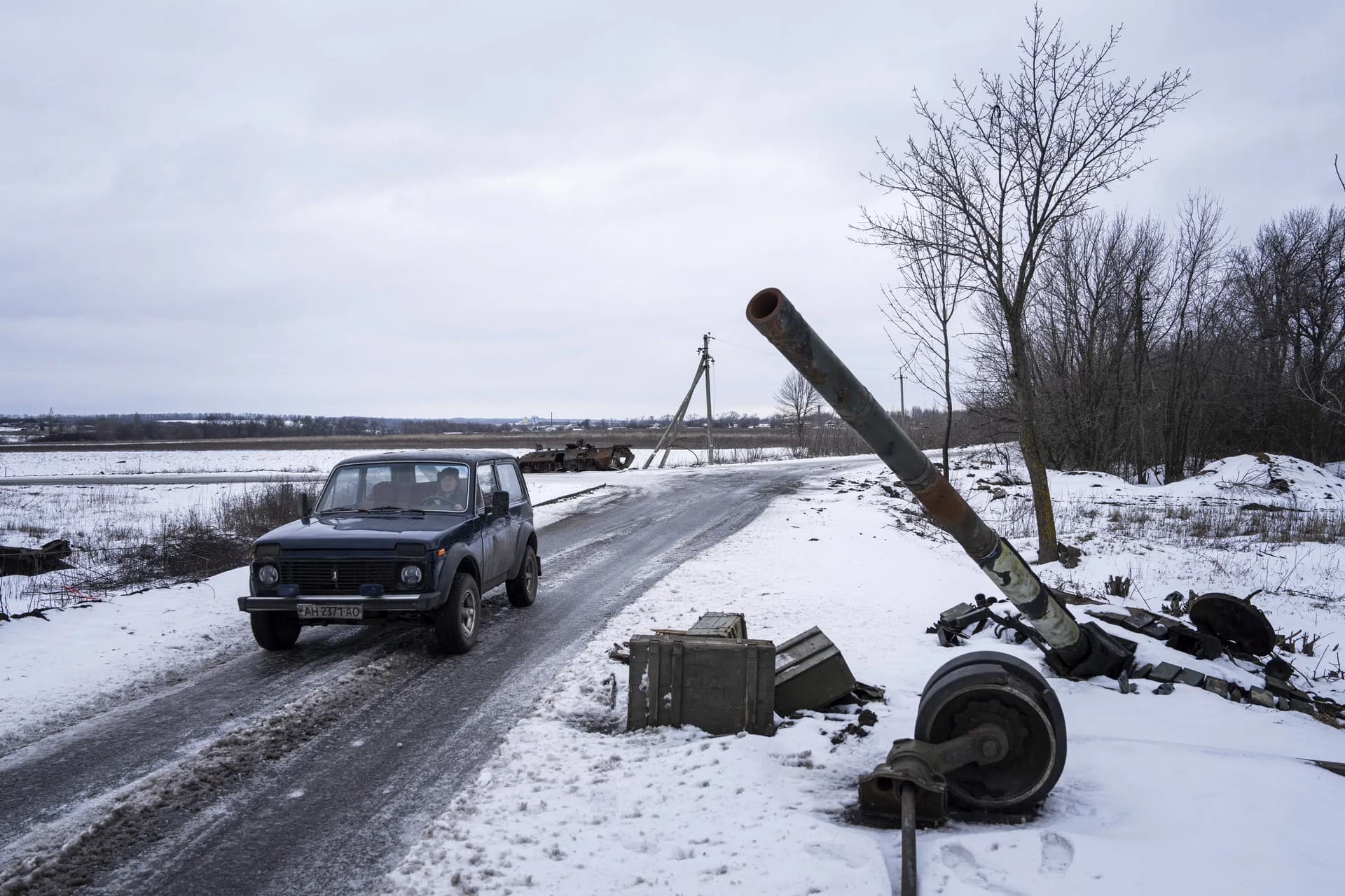 A car drives past a destroyed tank at the former positions of Russian forces in Ridkodub village