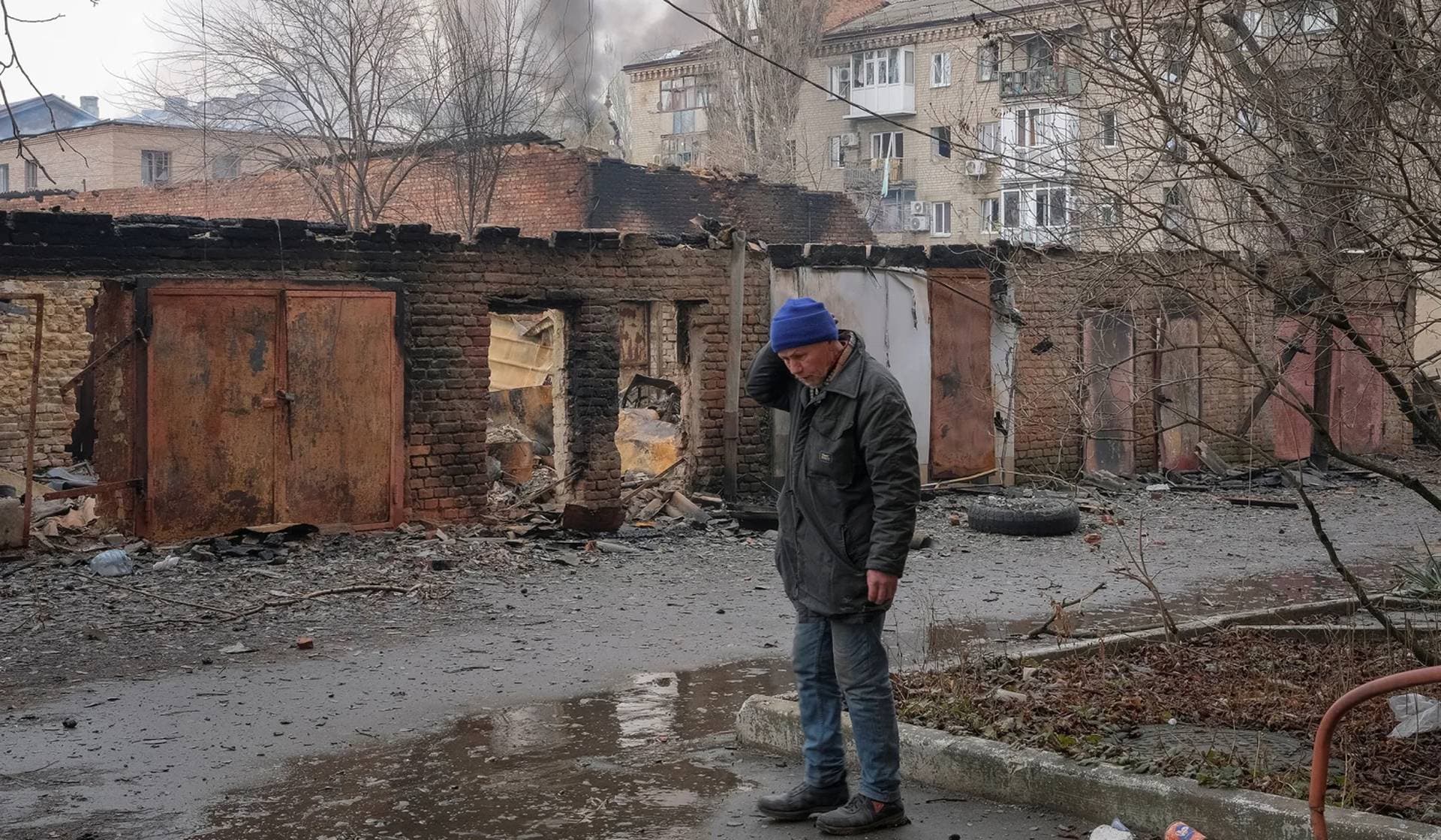 A local resident stands near buildings damaged by a Russian military strike in the frontline city of Bakhmut