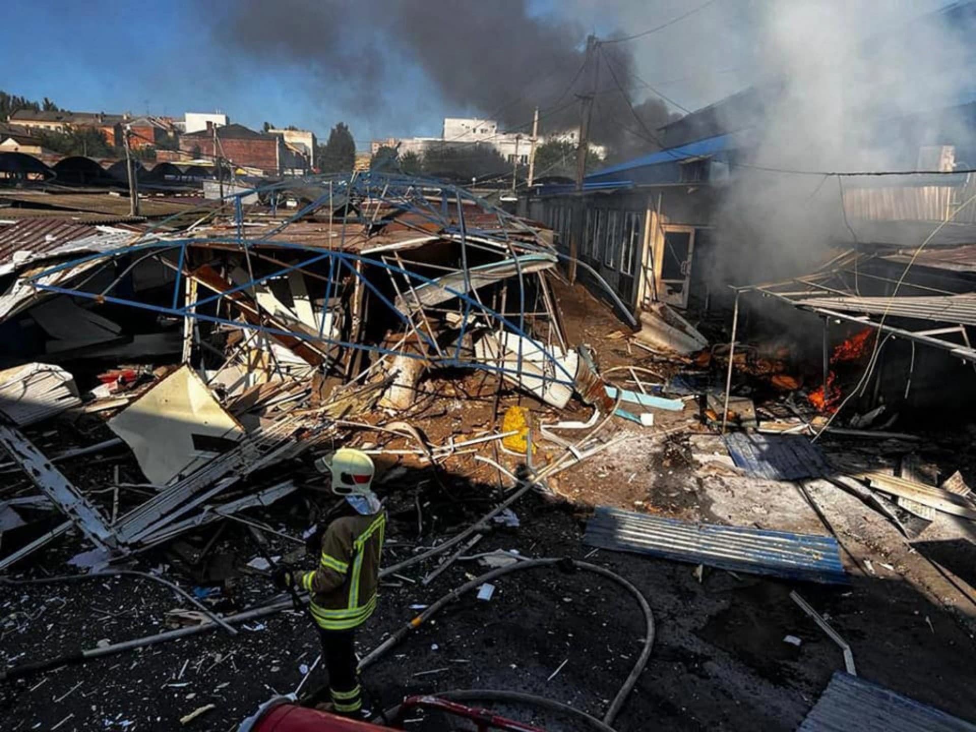 A firefighter extinguishes a fire at a market after shelling in Bakhmut