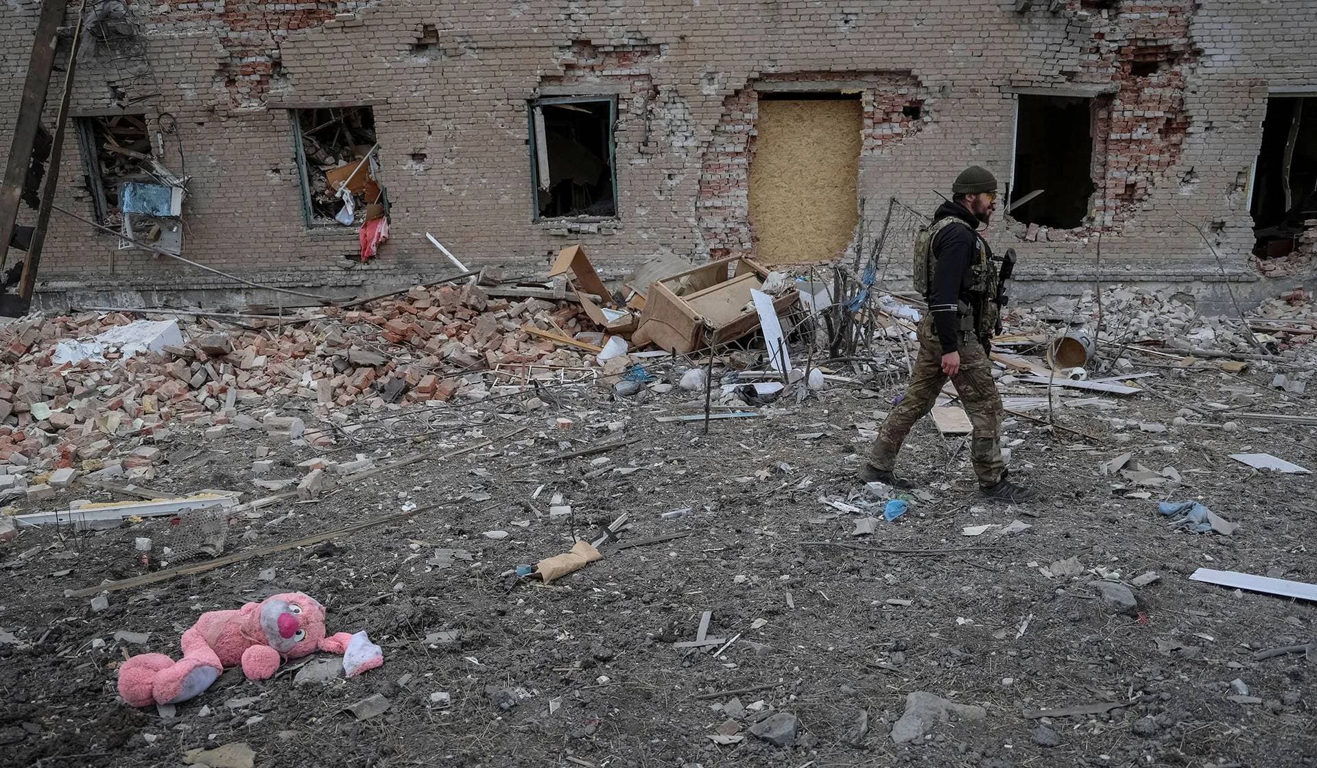 A Ukrainian serviceman walks near destroyed building in the frontline town of Chasiv Yar