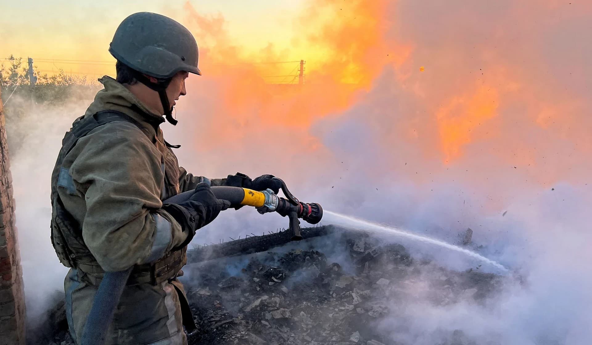 A Ukrainian firefighter puts out fire in a residential house after a Russian military strike in Bakhmut