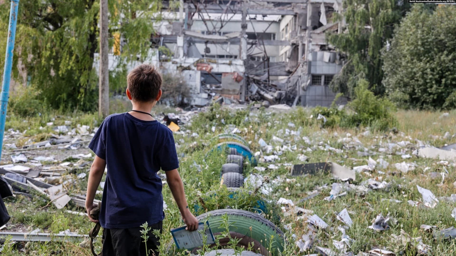 A boy views the aftermath of Russian shelling that destroyed his school in Bakhmut