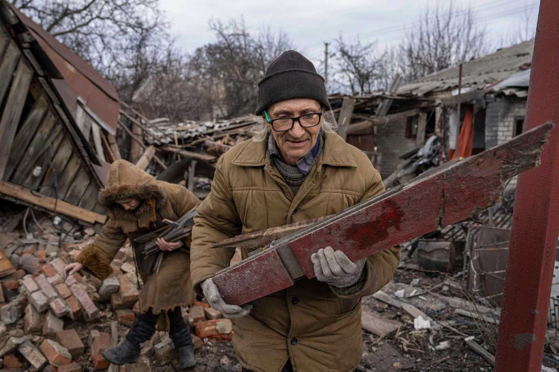 Hennadiy Mazepa and his wife Natalia Ishkova collect wood from a house which was destroyed by Russian forces in Chasiv Yar