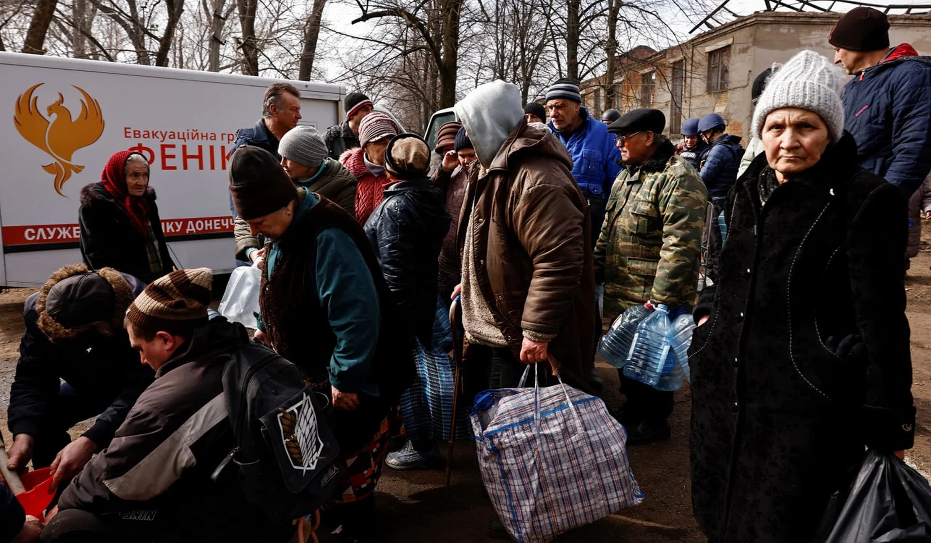 Residents line up to receive food and fill up bottles with fresh drinking water brought in to a neighbourhood near the frontline after critical civil infrastructure was hit in Chasiv Yar