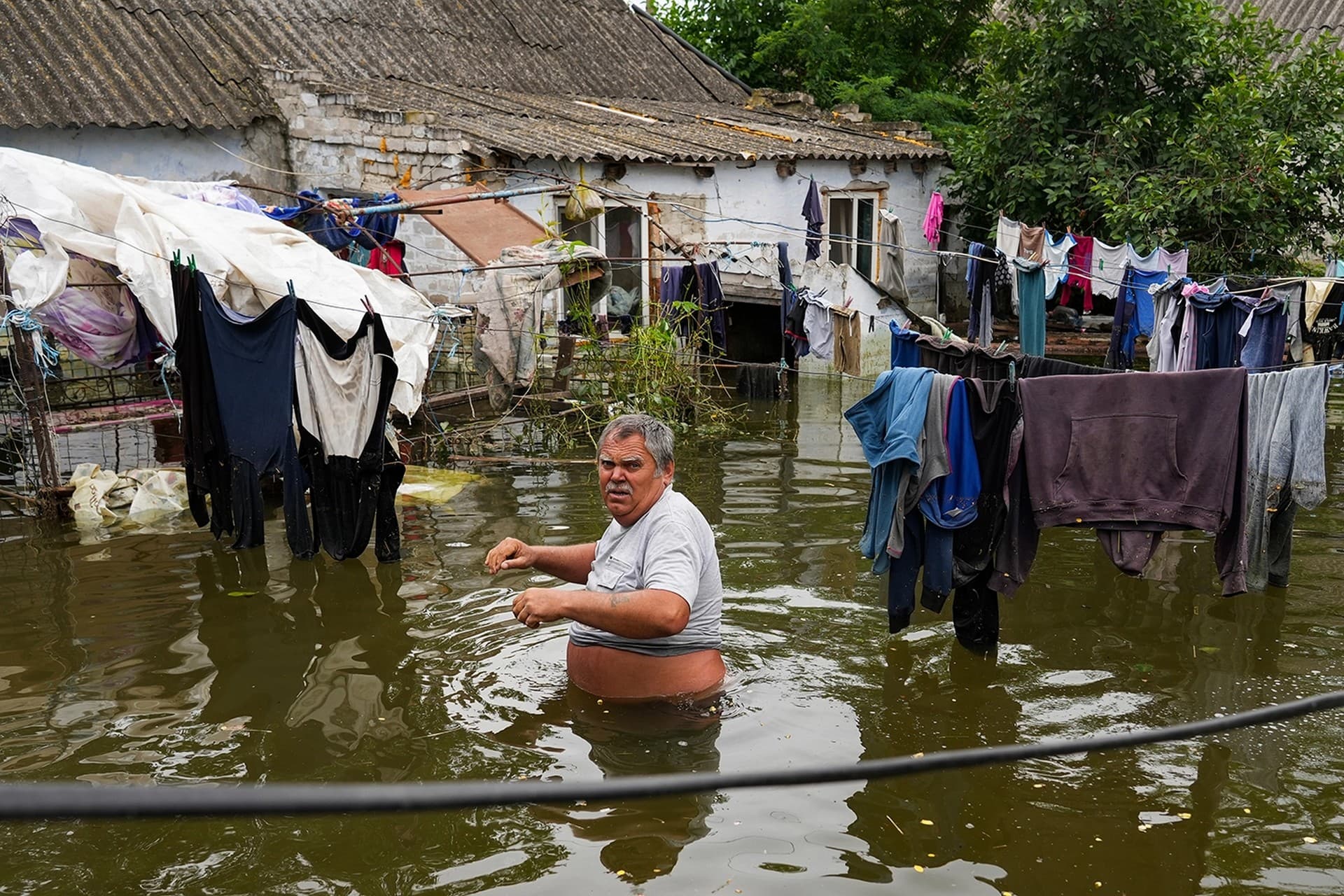 Local resident Yuriy walks in the flooded yard of his house in Afanasiyivka