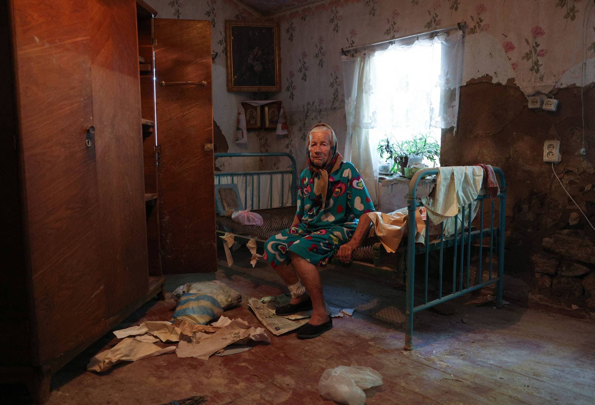 local resident of Afanasiyivka village sits in her damaged house due to flood following damage sustained to the Kakhovka hydroelectric power plant dam