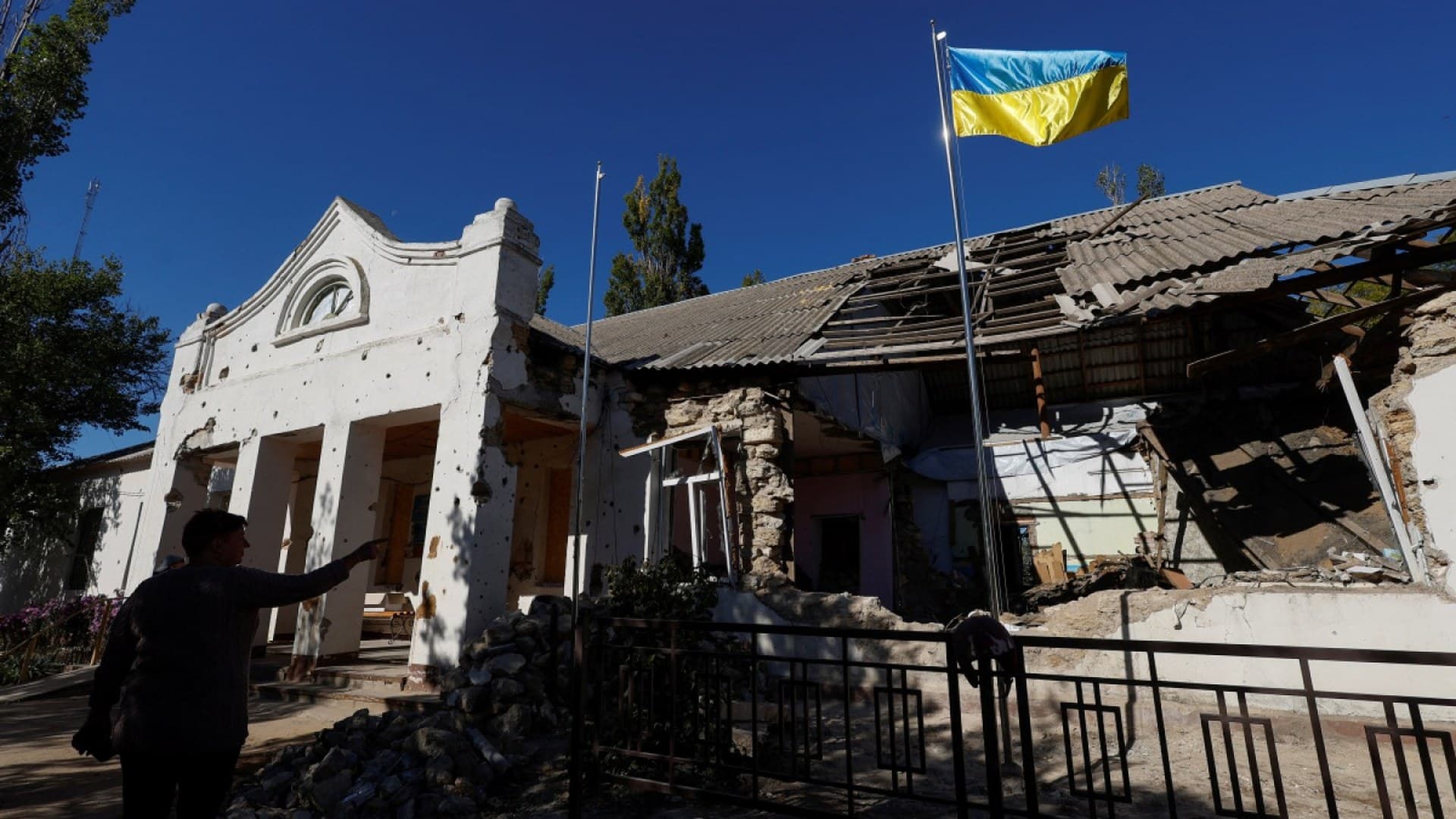 A Ukrainian national flag rises over a local council's headquarter building in the village of Lymany