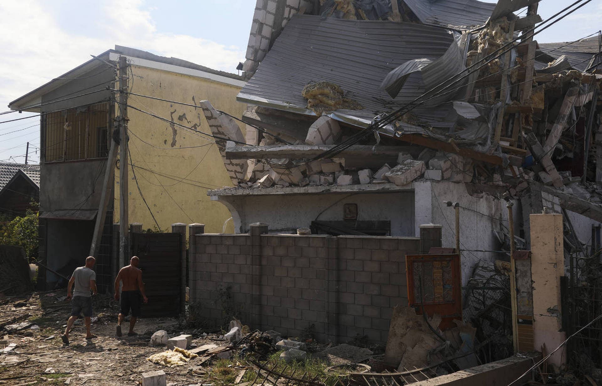 Men walk near buildings of local resort destroyed following recent Russian missile attacks in Odesa region
