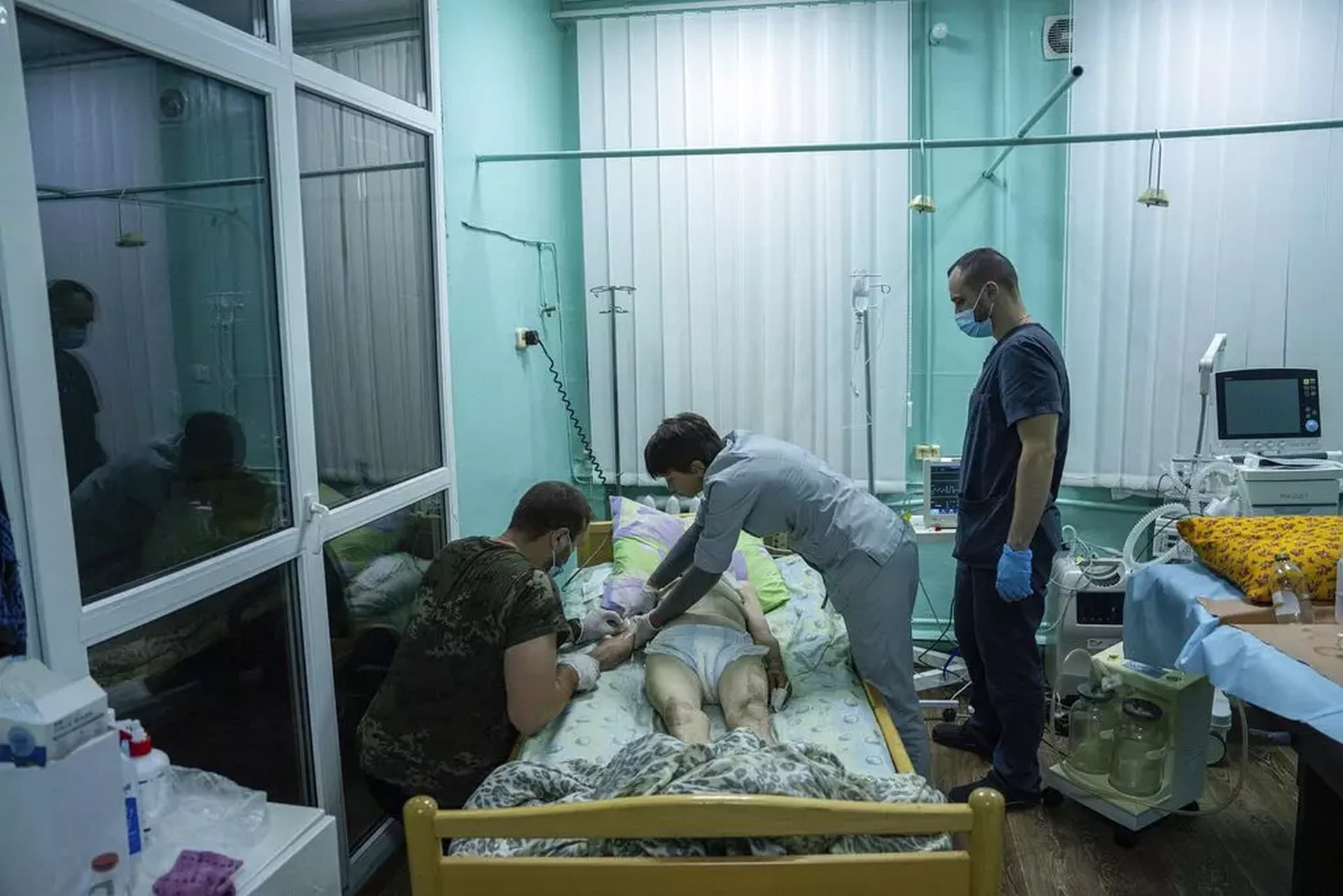 Medics treat en elderly woman at the ICU department in the hospital of Zolochiv