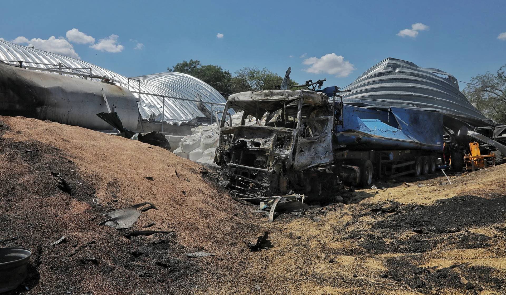 Barley and a damaged truck where a grain warehouse was destroyed by a Russian missile strike at a compound of an agricultural company in the village of Pavlivka