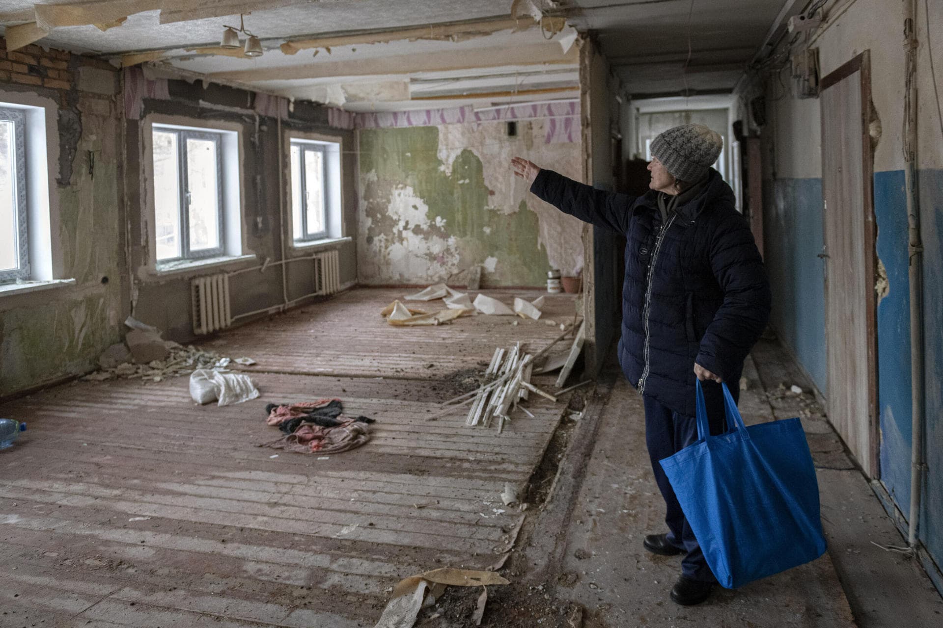 Zoya Pavliuk is pointing at the place where Russian missile hit the building in Borodyanka 