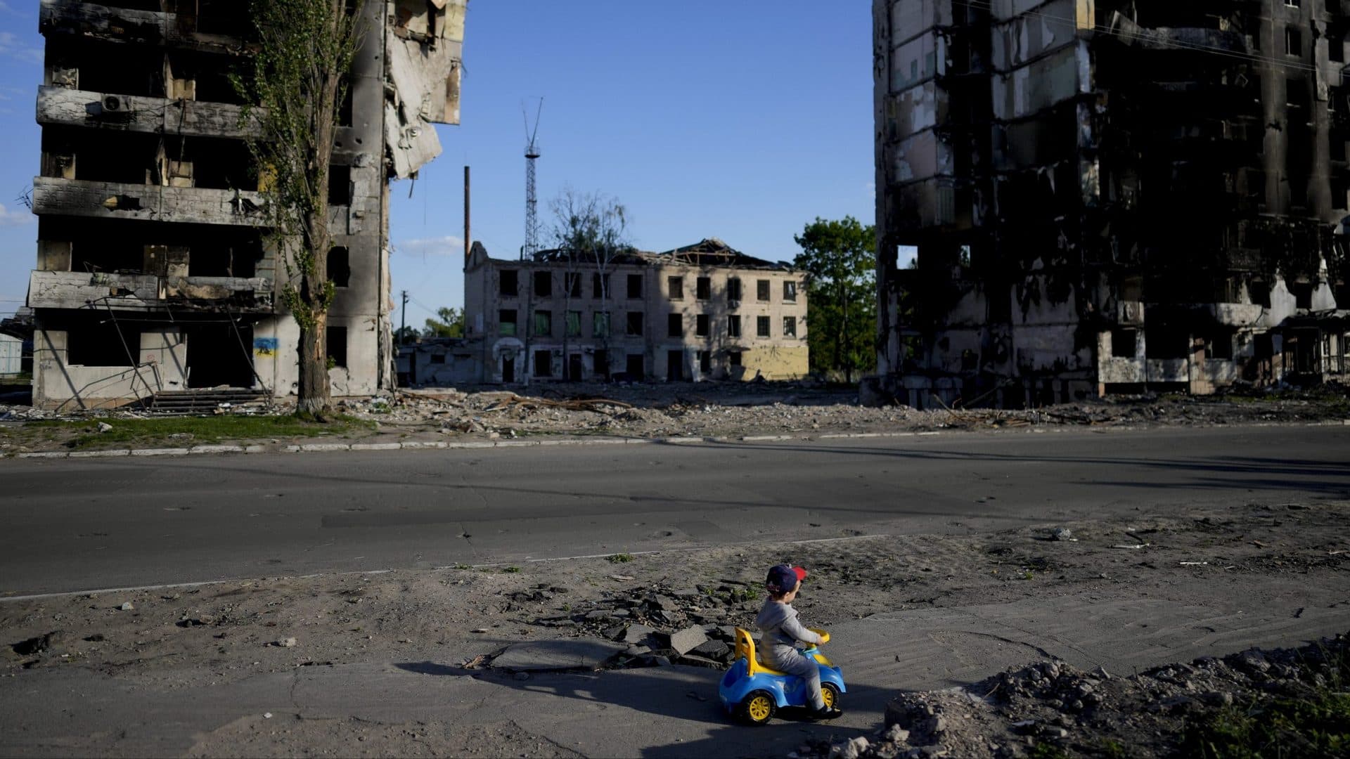 A boy plays in front of houses ruined by shelling in Borodyanka