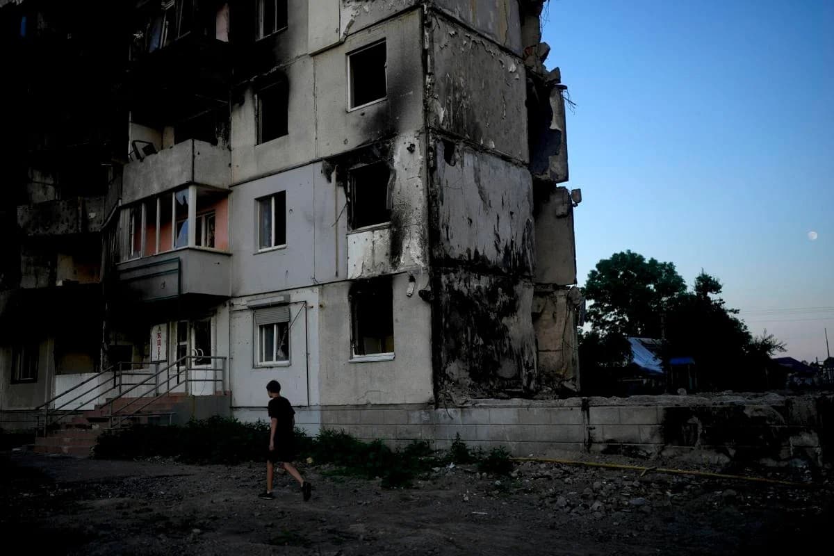 The moon is seen near a building destroyed by attacks in Borodyanka