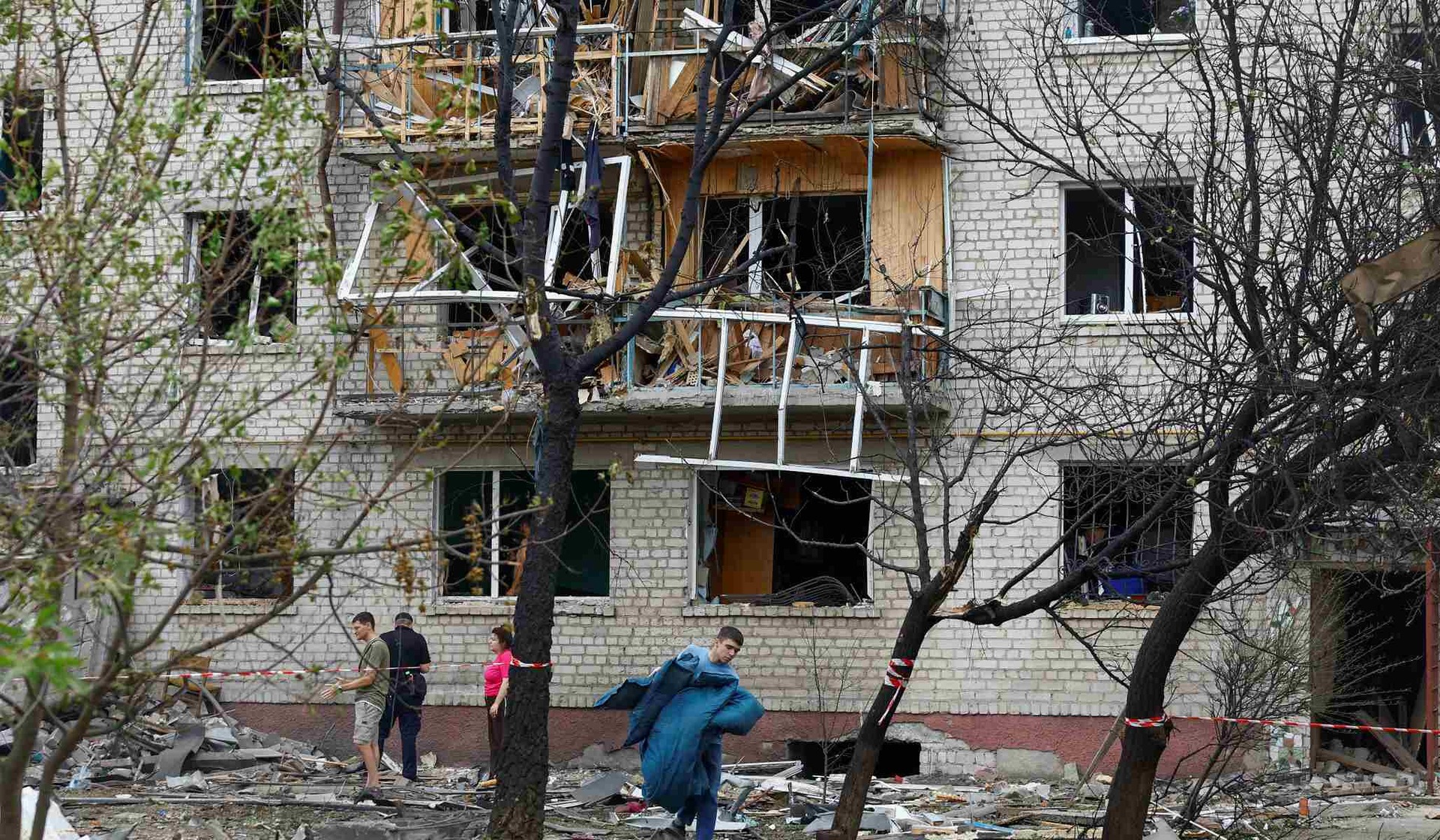 A man carries belongings from an apartment building damaged by a Russian missile strike in Boryspil