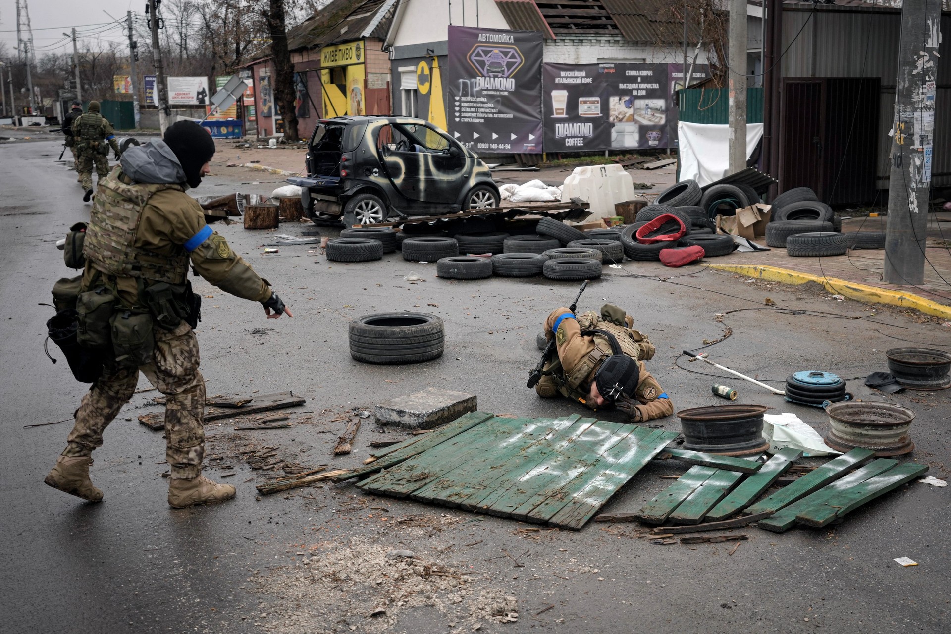 Ukrainian servicemen check streets for booby traps as Russian troops are retreating