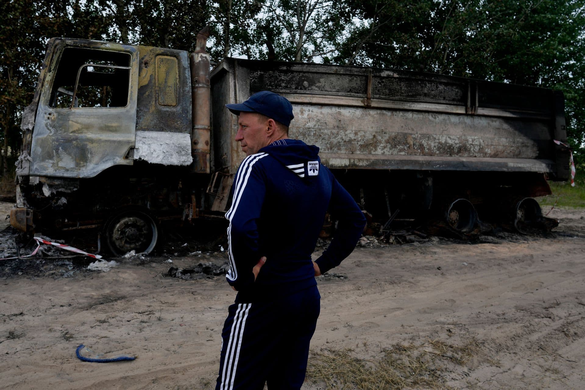 Vadym Schvydchenko stands next to his truck recentely damaged by a mine on a dirt track near Makariv, on the outskirts of Kyiv