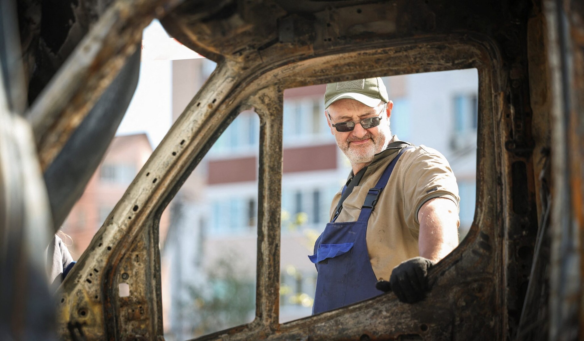 A man looks at his vehicle, which was destroyed in a Russian drone strike, in Vyshneve, Kyiv region