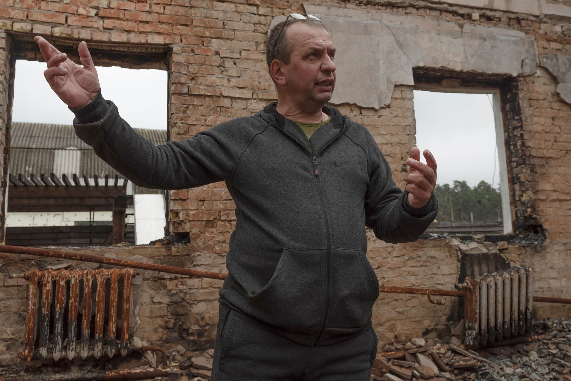Vadym Zherdetsky talks to The Associated Press amid the wreckage of his house destroyed by fighting, in the village of Moshchun