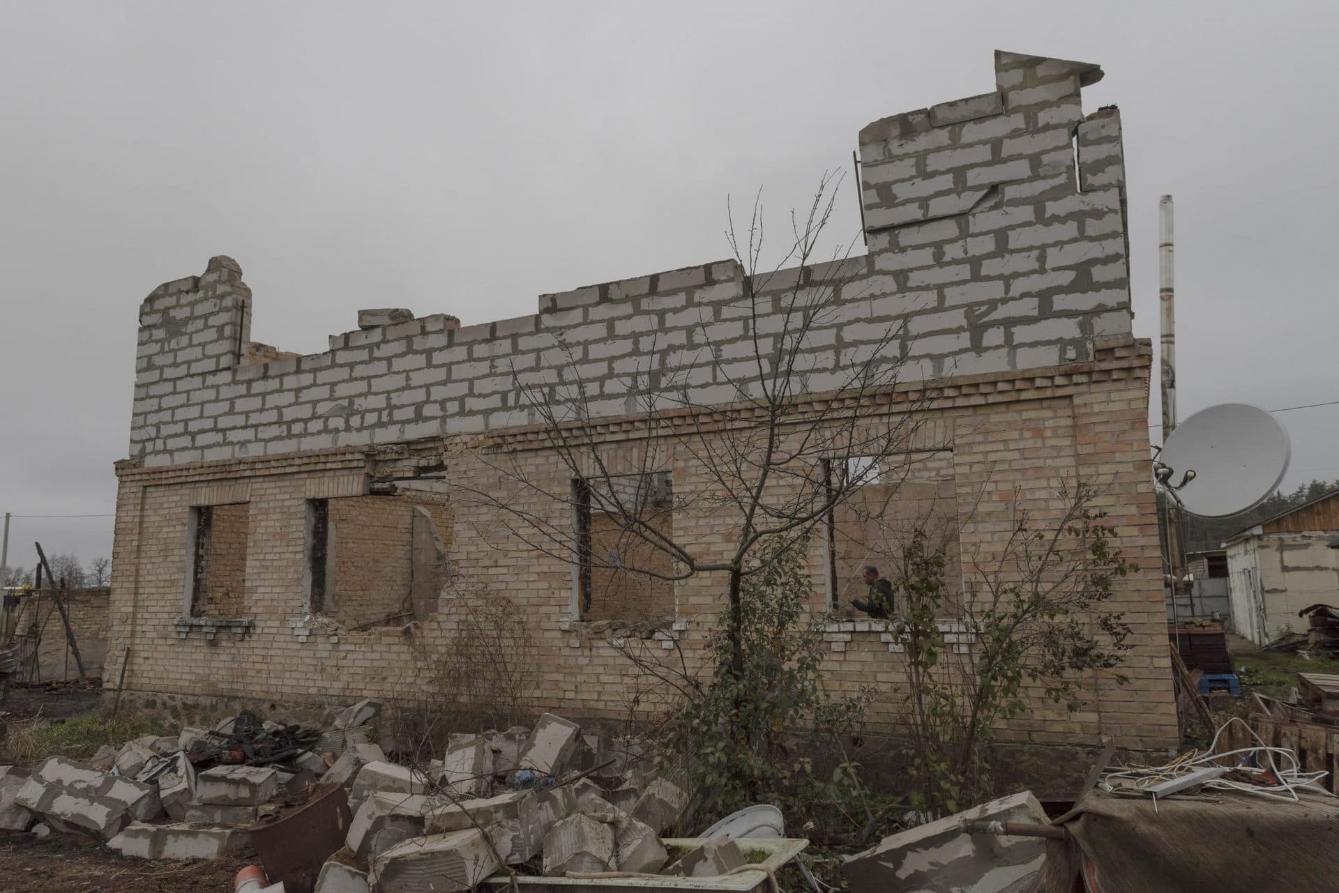 Vadym Zherdetsky stands in the remains of his house destroyed by fighting, in the village of Moshchun