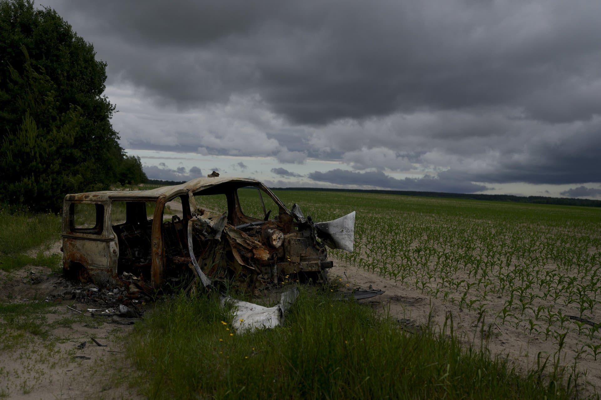 The wreckage of a burned out van that triggered an anti-tank mine, killing its three occupants, lies by the side of a dirt track in Andriyivka, on the outskirts of Kyiv