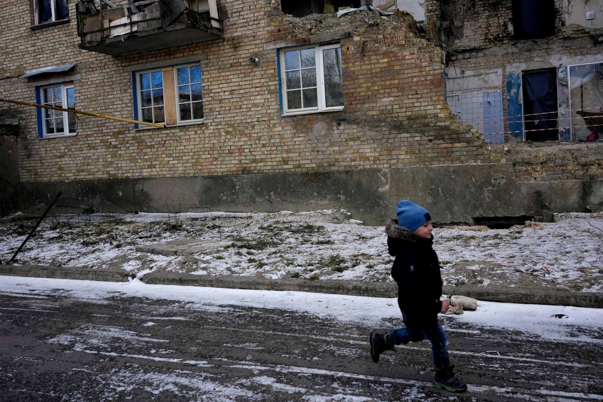 Matvii Sotnichenko, 4, runs near a destroyed building in Horenka
