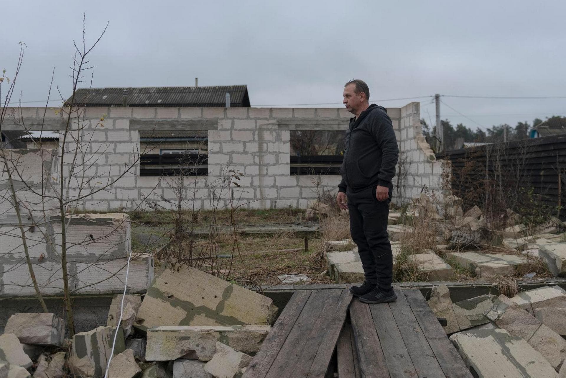Vadym Zherdetsky stands amid the wreckage of his house destroyed by fighting in the village of Moshchun