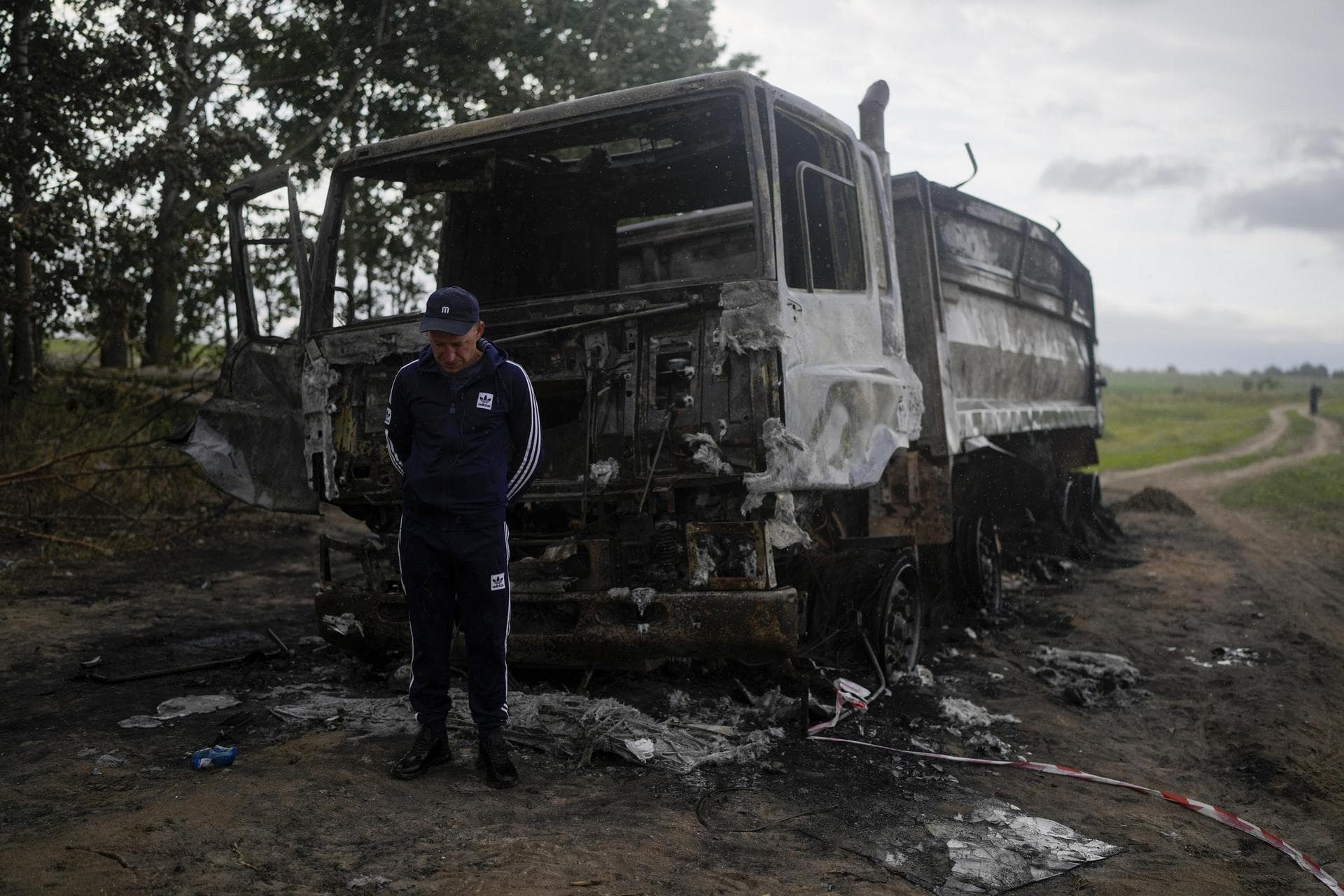 Vadym Schvydchenko stands next to his truck recentely damaged by a mine on a dirt track near Makariv, on the outskirts of Kyiv