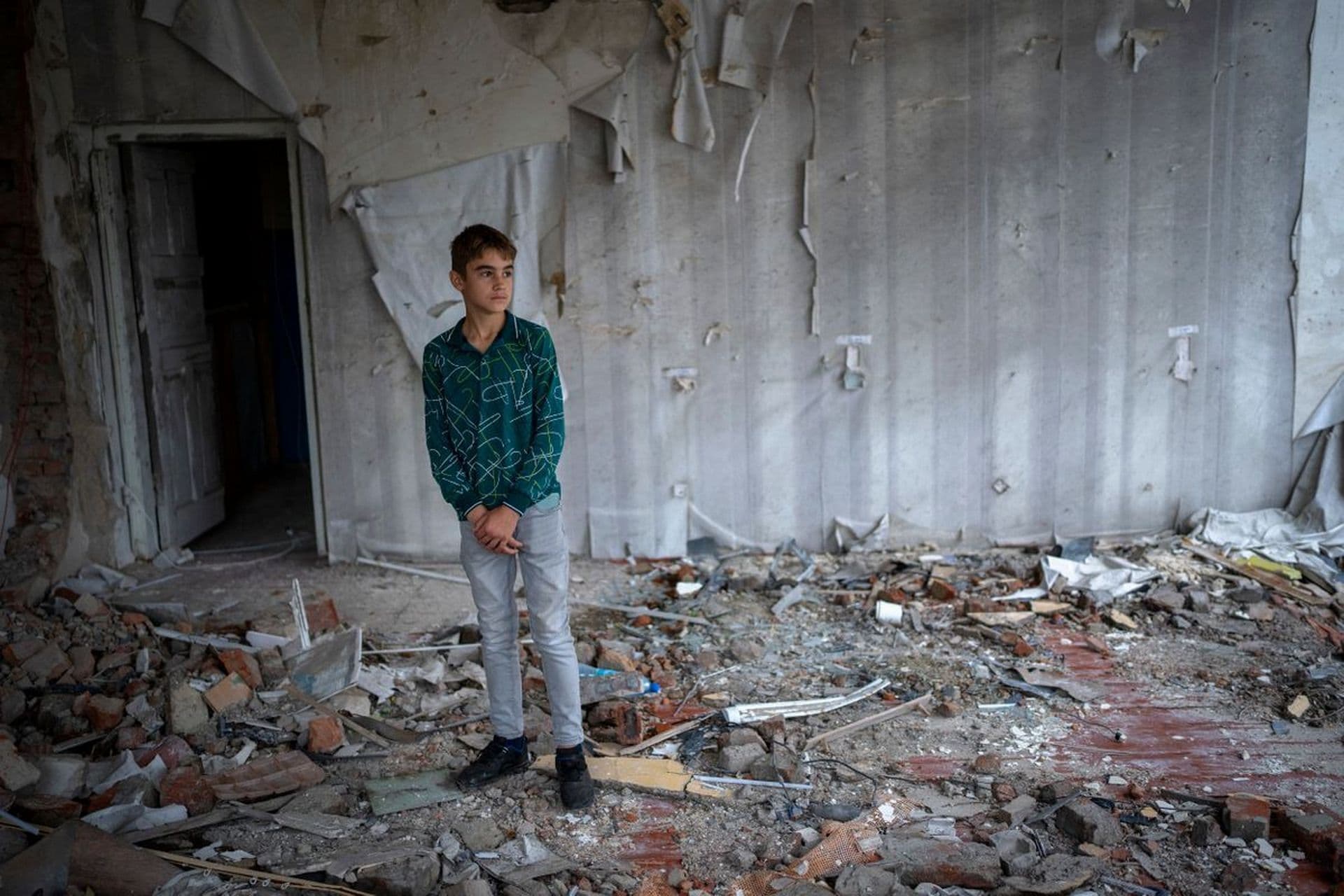 Oleksii Lytvyn stands in the rubble of his former classroom, in the same position where his desk sat before the Mykhailo-Kotsyubynske's lyceum was bombed by Russian forces on March 4, in Chernihiv
