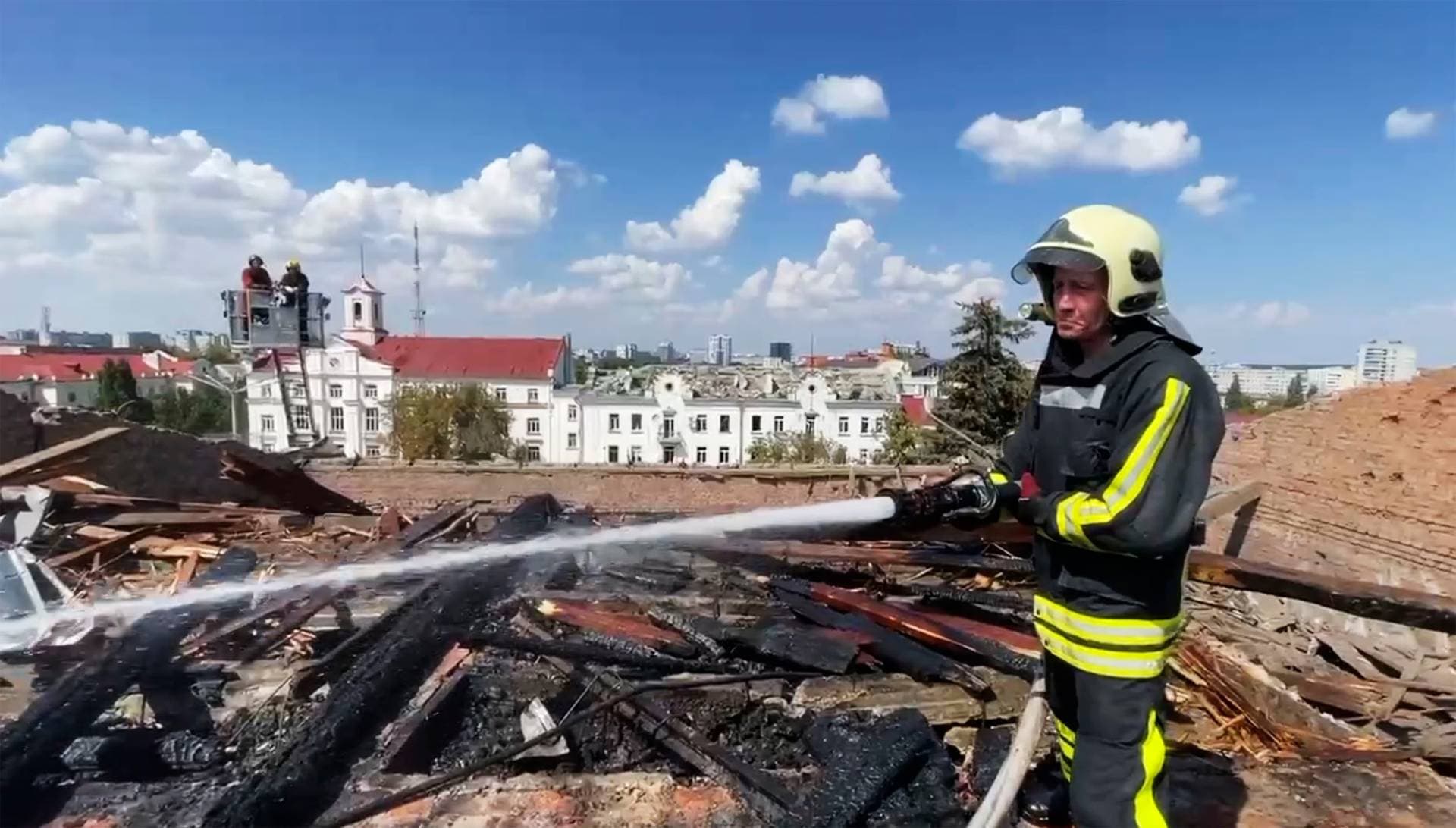 firefighters work on a roof of the Taras Shevchenko Chernihiv Regional Academic Music and Drama Theatre damaged by Russian attack in Chernihiv