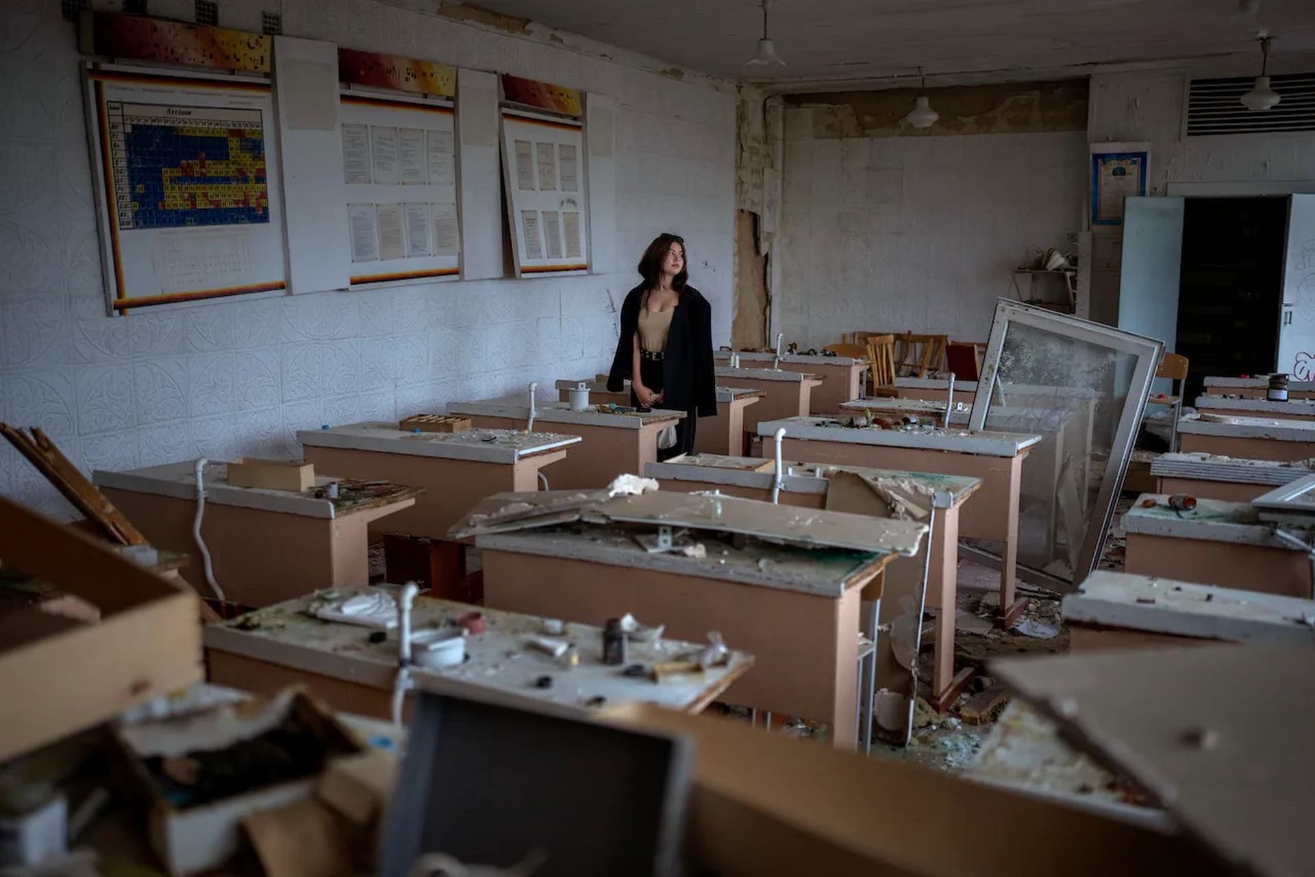 Surrounded by shards of broken glass and rubble Khrystyna Ignatova, sits at her desk in the remains of her classroom in the Chernihiv School #21