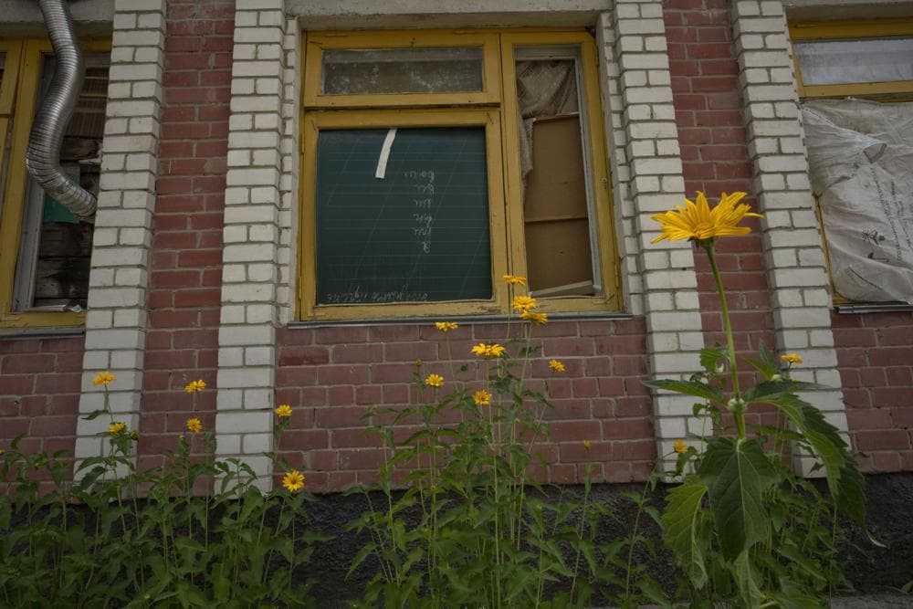 Flowers grow outside a school damaged from Russian strikes, in Yahidne village, northern Chernihiv region