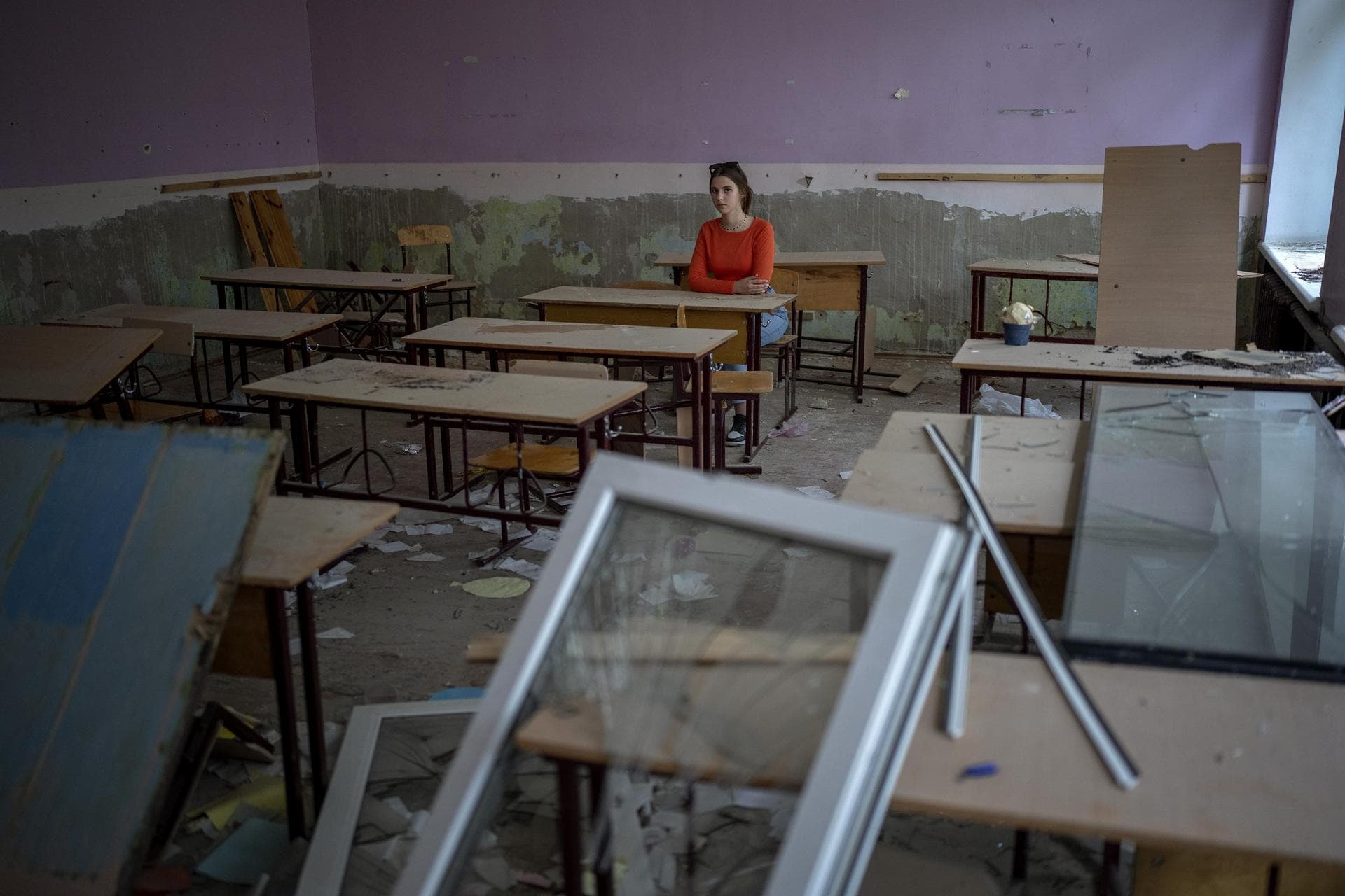 Surrounded by shards of broken glass and rubble 14-year-old Sofia Zhyr, sits at her desk in the remains of her classroom in the Chernihiv School #21