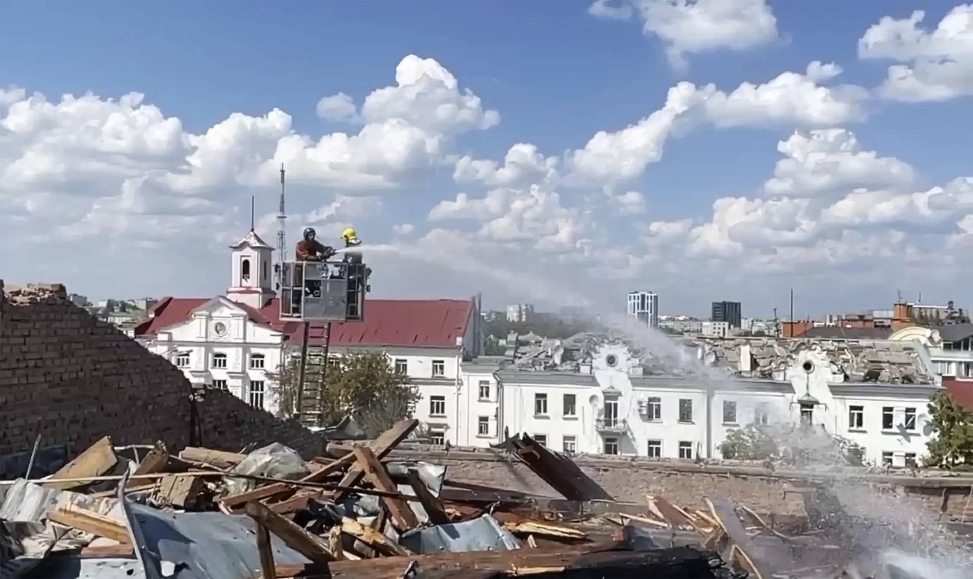 firefighters work on a roof of the Chernihiv Regional Academic Music and Drama Theatre damaged by Russian attack in Chernihiv