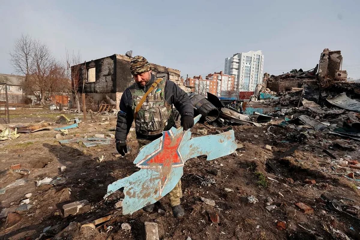 A Ukrainian Terodefense soldier holds a fragment of a Russian Su-34 combat aircraft in Chernihiv