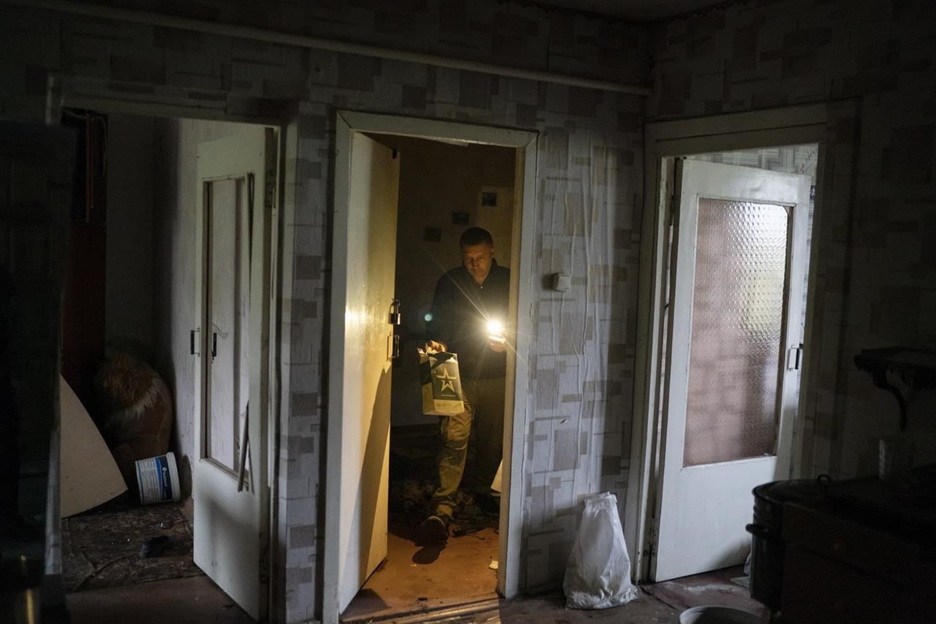 Anatolii Klyzhen carries an empty Russian army food ration packet that was left in his apartment while occupied by the Russian soldiers in the freed village of Hrakove
