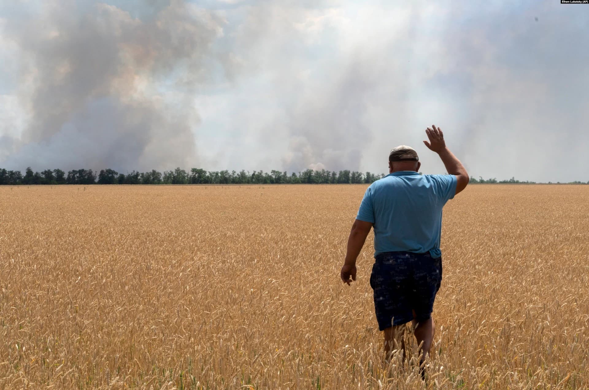 A Ukrainian farmer in the Dnipropetrovsk region watches as patches of his wheat fields burn as a result of fighting on July 4