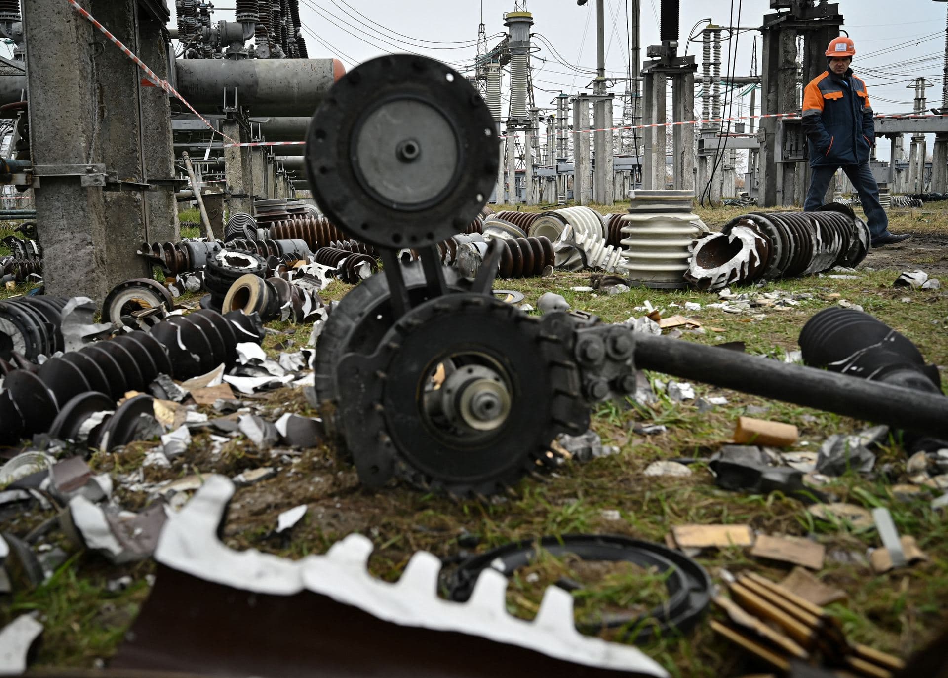 A worker walks past damaged equipment at a high-voltage substation of the operator Ukrenergo after a missile attack