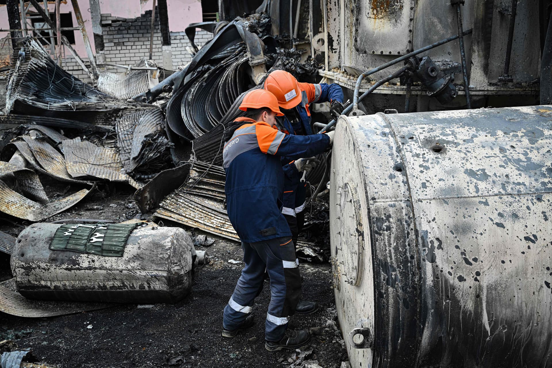 Employees work on damaged equipment at a high-voltage substation of the operator Ukrenergo after a missile attack