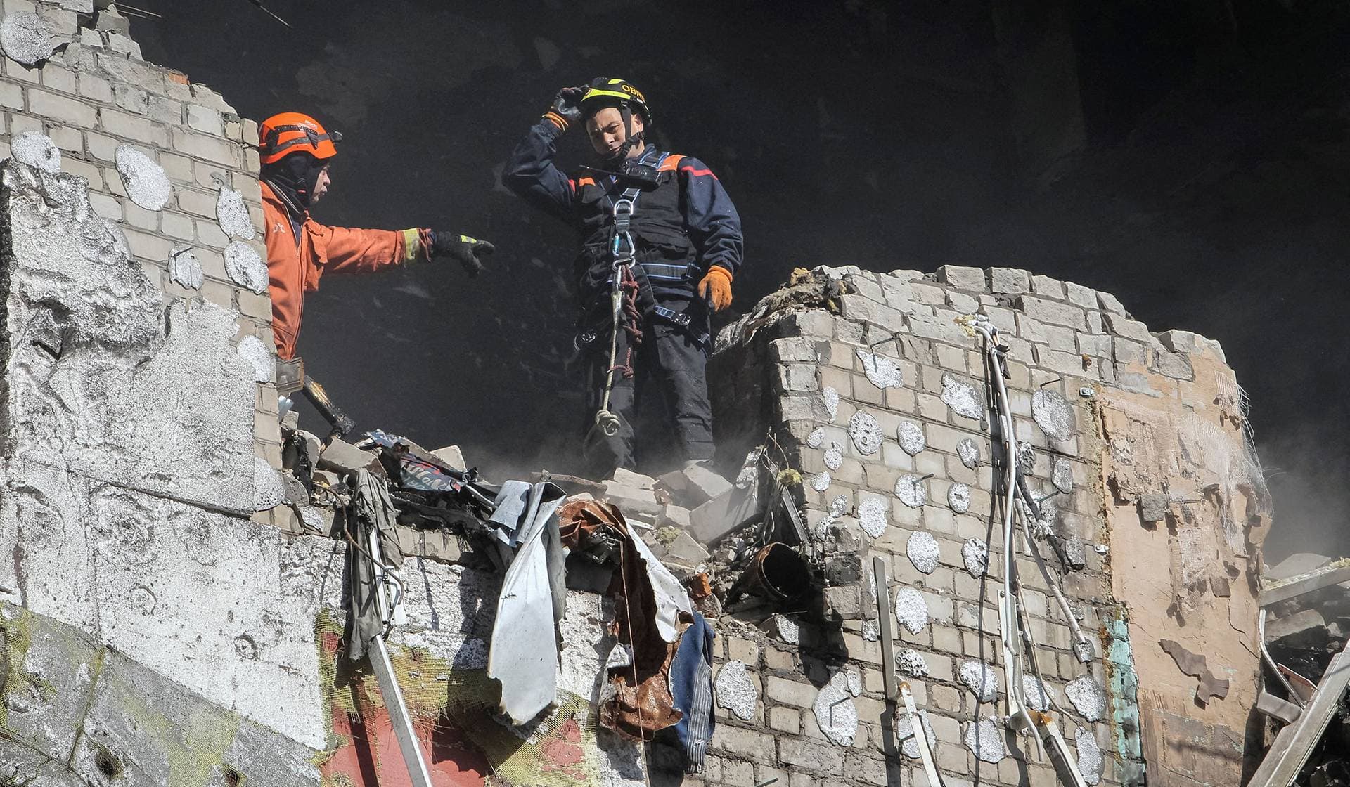 Rescuers work at the site of an apartment building hit by a Russian drone strike in Dnipro