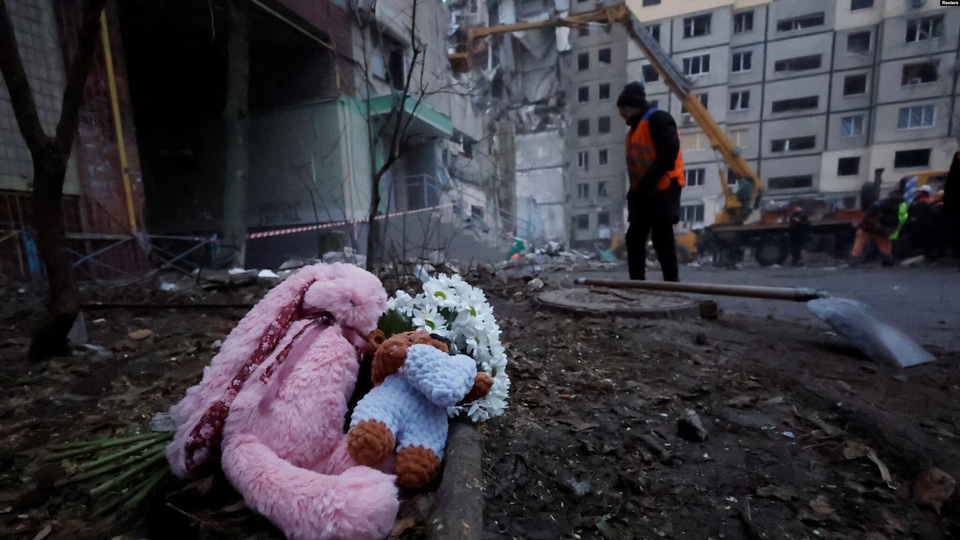 Tributes are left at an apartment block that was heavily damaged by a Russian missile strike, killing dozens inside, in Dnipro